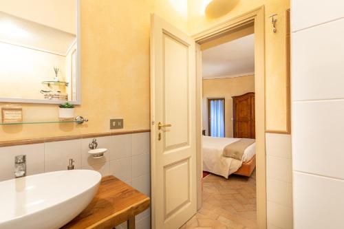a bathroom with a sink and a mirror and a bed at La Terrazza, Cetona, Toscana in Cetona