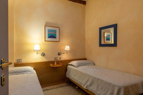 a room with two beds and two lights on the wall at La Terrazza, Cetona, Toscana in Cetona