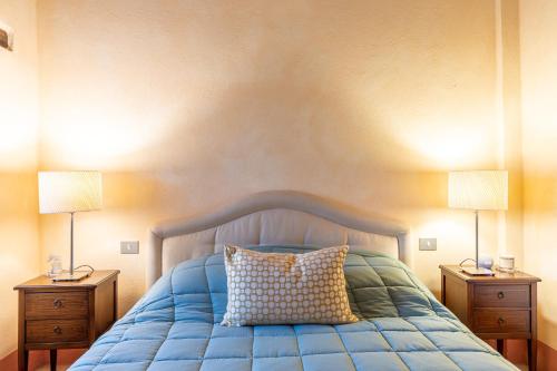 a bedroom with a blue bed with two night stands at La Terrazza, Cetona, Toscana in Cetona