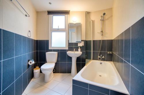 a bathroom with a toilet and a sink and a tub at Pafilia Gardens 6 in Paphos