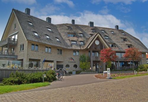 a large stone building with a gambrel roof at Vlierijck in Oost-Vlieland