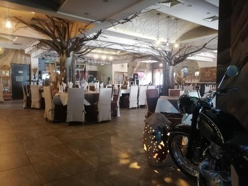 a restaurant with tables and a motorcycle parked in a room at Hotel Talija in Svilajnac