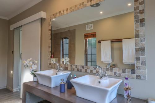 a bathroom with two sinks and a large mirror at Cornerstone Connection in Durban