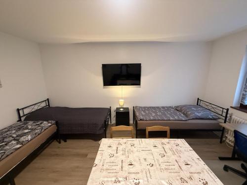 a room with two beds and a flat screen tv at Cosy, beautiful and central apartment in Karlsruhe