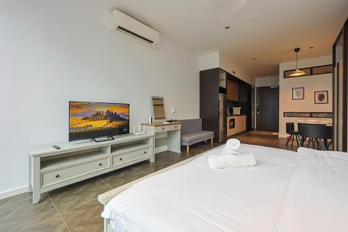 a bedroom with a white bed and a flat screen tv at Borderless Swimming Pool - Invincible Twin Towers View - Free WiFi in Kampong Gombak Utara