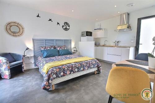 a bedroom with a bed and a small kitchen at Ty ar bleuenn in Penvénan