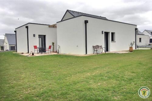 a white house with a lawn in front of it at Ty ar bleuenn in Penvénan