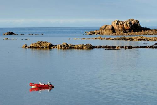 a red boat in the middle of a body of water at Ty ar bleuenn in Penvénan