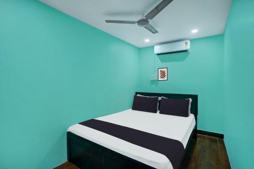 a bedroom with a bed with blue walls and a ceiling at Super Hotel O Grill Inn in Dhanbād