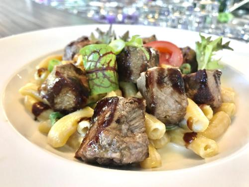 a plate of food with meat pasta and vegetables at Hotel Engel Buch in Albbruck