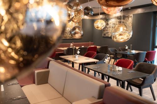 a restaurant with tables and chairs and lights at PLAZA Premium Heidelberg in Heidelberg