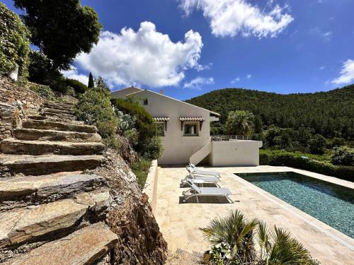 une maison avec une piscine à côté d'une montagne dans l'établissement Villa Blanche pour 8 personnes avec piscine privée à La Londes-Les-Maures, à La Londe-les-Maures