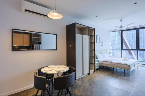 a room with a table and chairs and a bed at Borderless Swimming Pool - Invincible Twin Towers View - Free WiFi in Kampong Gombak Utara
