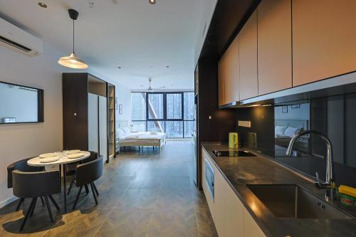 a kitchen with a table and a dining room at Borderless Swimming Pool - Invincible Twin Towers View - Free WiFi in Kampong Gombak Utara