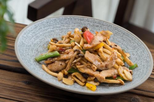 a plate of food on a wooden table at Sanhe Daoli Resort in Qingyuan