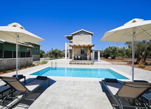 a swimming pool with two chairs and two umbrellas at Villa Penelope Halipoma in Lefkada Town