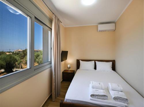 a bedroom with a bed and a large window at Villa Penelope Halipoma in Lefkada Town