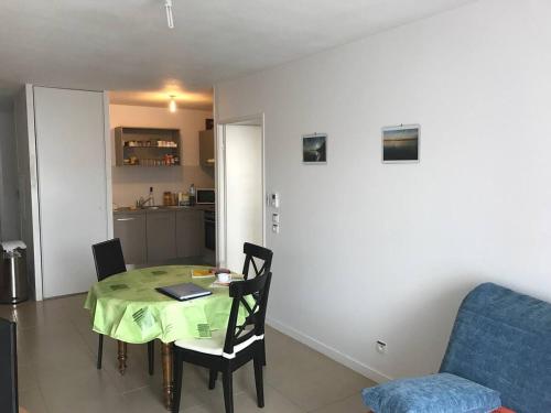 un salon avec une table et un canapé et une cuisine dans l'établissement Arcachon centre résidence récente, à Arcachon