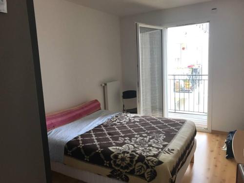 une chambre avec un lit et une grande fenêtre dans l'établissement Arcachon centre résidence récente, à Arcachon