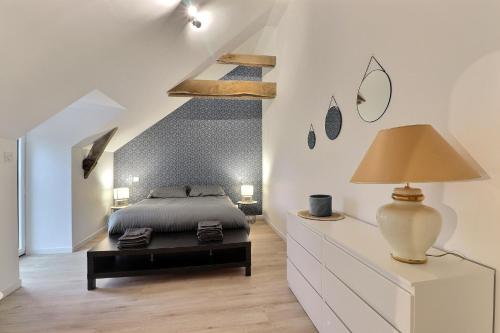 a bedroom with a bed and a table with a lamp at Château des Cours - Gîte La Providence in Taillis