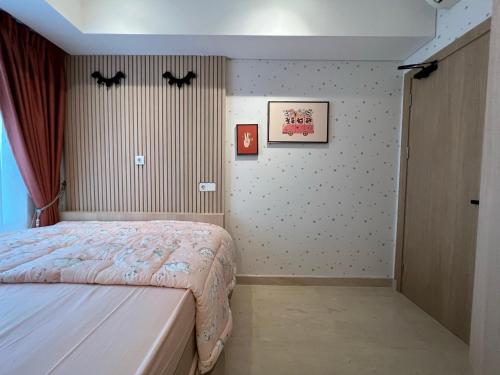 a bedroom with a bed with bats on the wall at Podomoro City Deli Medan Tower Empire - Japandi Style - 2BR Family Suite 3 beds - 87m in Medan