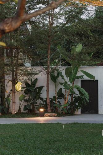 a building with a door and some trees and grass at Sanhe Daoli Resort in Qingyuan