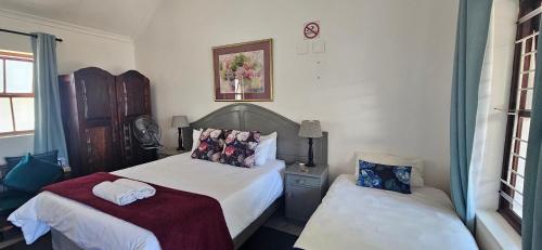a bedroom with two beds and a window at Kelkiewyn Guesthouse Caledon in Caledon
