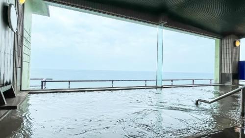 a swimming pool in a building with a large window at Taiseisou - Vacation STAY 90012v in Murakami