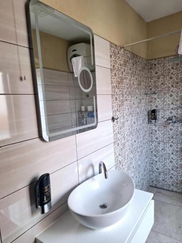 a bathroom with a white sink and a mirror at Palace Derossi in Trogir