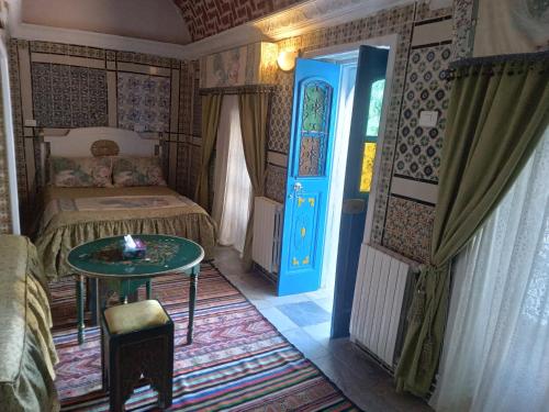 a bedroom with a bed and a blue door at Hôtel Bou Fares in Sidi Bou Saïd
