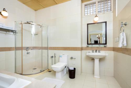 a bathroom with a shower toilet and a sink at Koder House in Cochin