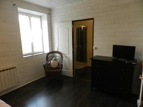 a room with a television and a dresser and a window at les chambres du parc in Dammarie-sur-Saulx