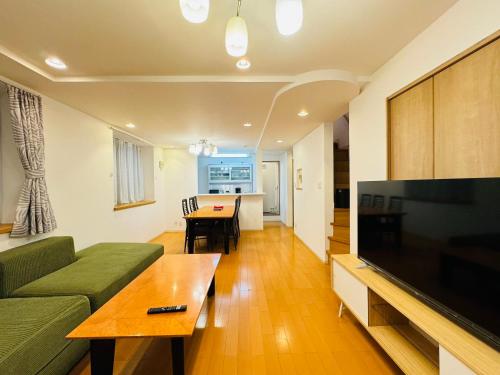 a living room with a couch and a tv and a table at PUSU-OKUBO House 3LDK-SJ0079 in Tokyo