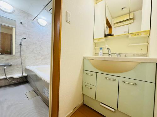 a bathroom with a sink and a bath tub at PUSU-OKUBO House 3LDK-SJ0079 in Tokyo