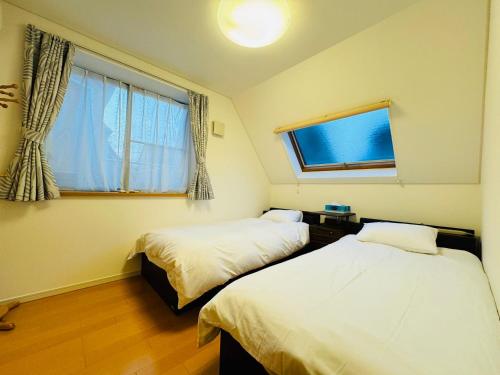 two beds in a room with a window and a window at PUSU-OKUBO House 3LDK-SJ0079 in Tokyo