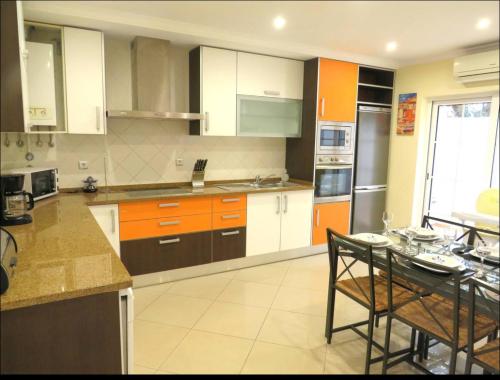 a kitchen with orange and white cabinets and a table at Casa Sarena in Altura