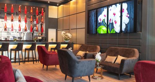 a waiting room with chairs and a bar at PLAZA Premium Heidelberg in Heidelberg