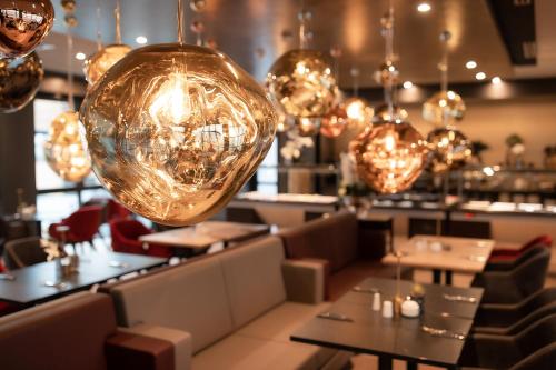 a restaurant with tables and chairs and lights at PLAZA Premium Heidelberg in Heidelberg