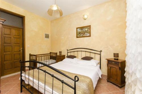 a bedroom with a large bed and a wooden door at Palace Derossi in Trogir