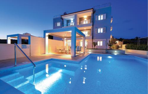 a swimming pool in front of a building at Cozy Apartment In Rogoznica With Sauna in Rogoznica