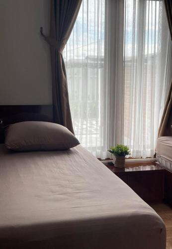 a bedroom with a bed with a large window at Homestay Omah Embun in Godean