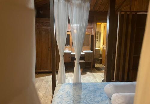 a view of a bedroom with a bed and a mirror at Homestay Omah Embun in Godean