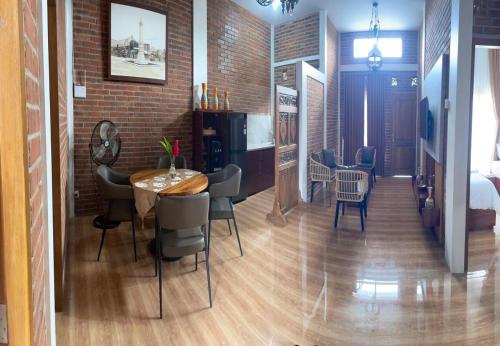 a room with a table and chairs and a brick wall at Homestay Omah Embun in Godean
