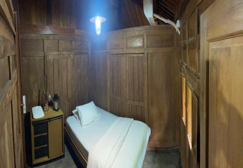 a small room with a bed and a telephone at Homestay Omah Embun in Godean