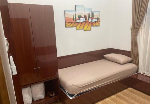 a small room with a bed and a painting on the wall at Homestay Omah Embun in Godean