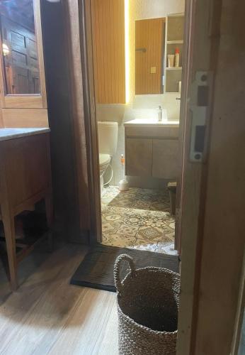 a bathroom with a toilet and a sink and a basket at Homestay Omah Embun in Godean