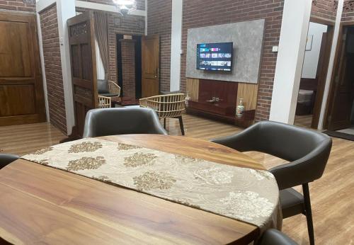 a conference room with a table and chairs and a tv at Homestay Omah Embun in Godean