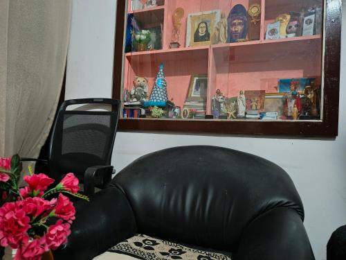 a black leather chair sitting in a room with flowers at Queen Mary's Homestay in Cochin