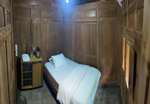 a small bedroom with a bed and a telephone at Homestay Omah Embun in Godean