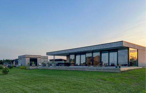 Casa grande con ventanas de cristal en un campo de césped en Amazing Home In Børkop With Wifi, en Børkop